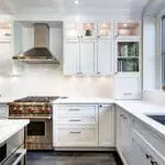 Bright white shaker-style kitchen with freshly painted cabinets, subway tile backsplash, and quartz countertops.