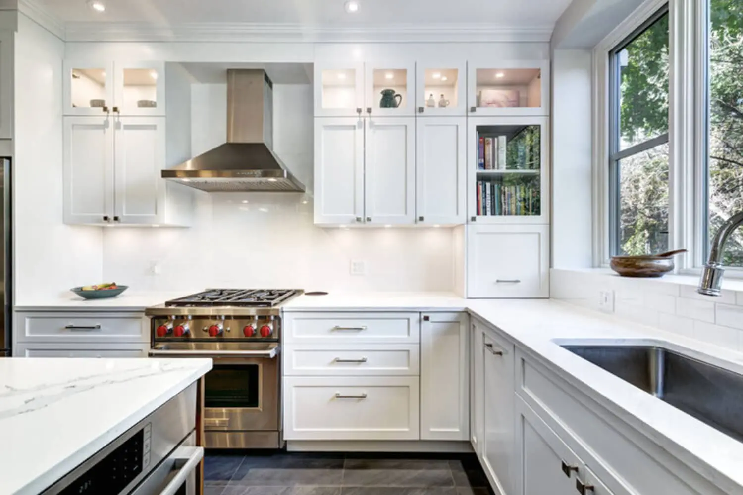 Bright white shaker-style kitchen with freshly painted cabinets, subway tile backsplash, and quartz countertops.