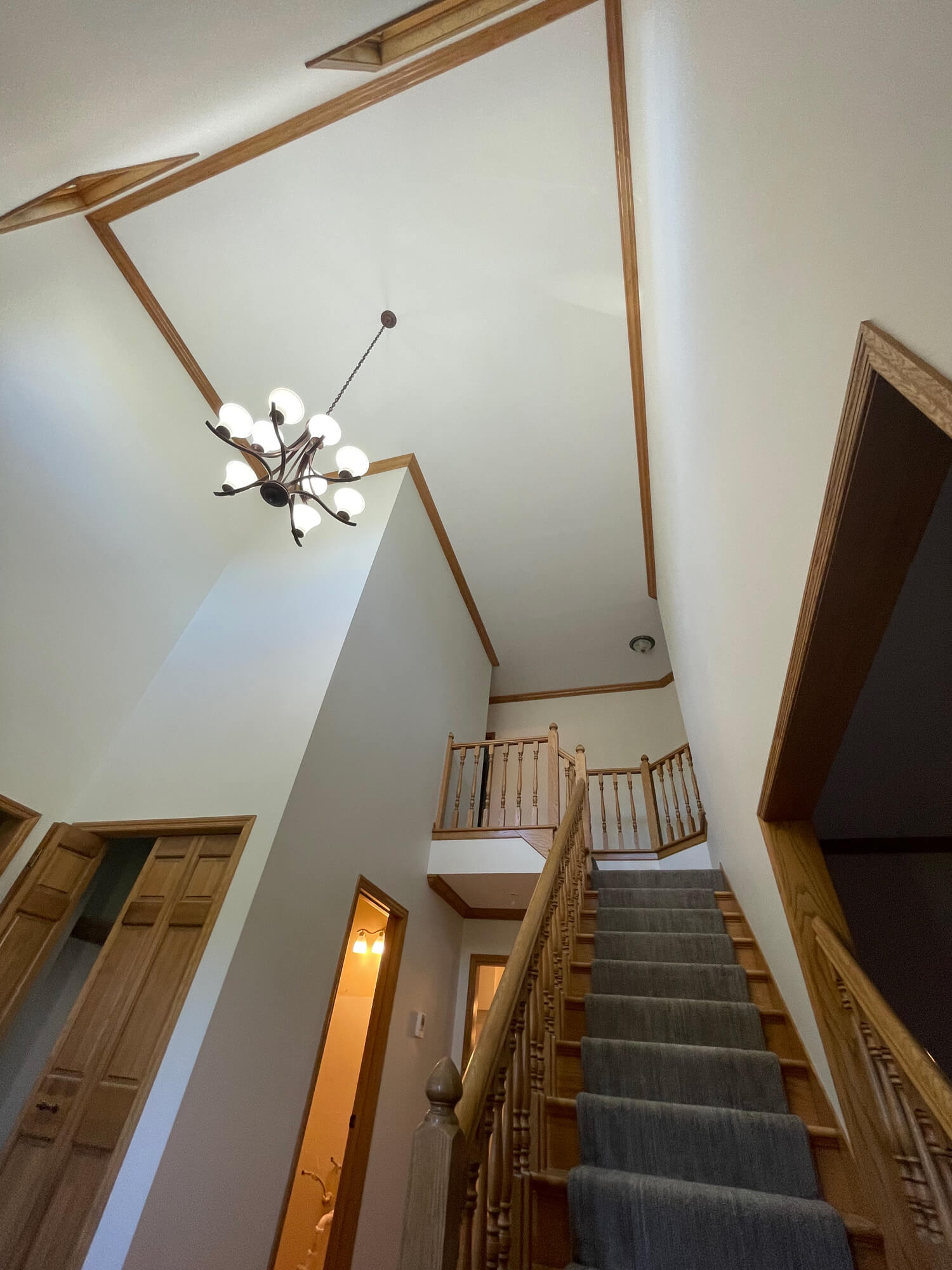 Residential interior painting service by Chrave Davis Painting, showcasing flawless finish on a high-ceiling entry and stairwell in a Minnesota home.