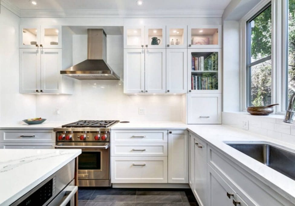 Bright white shaker-style kitchen with freshly painted cabinets, subway tile backsplash, and quartz countertops.